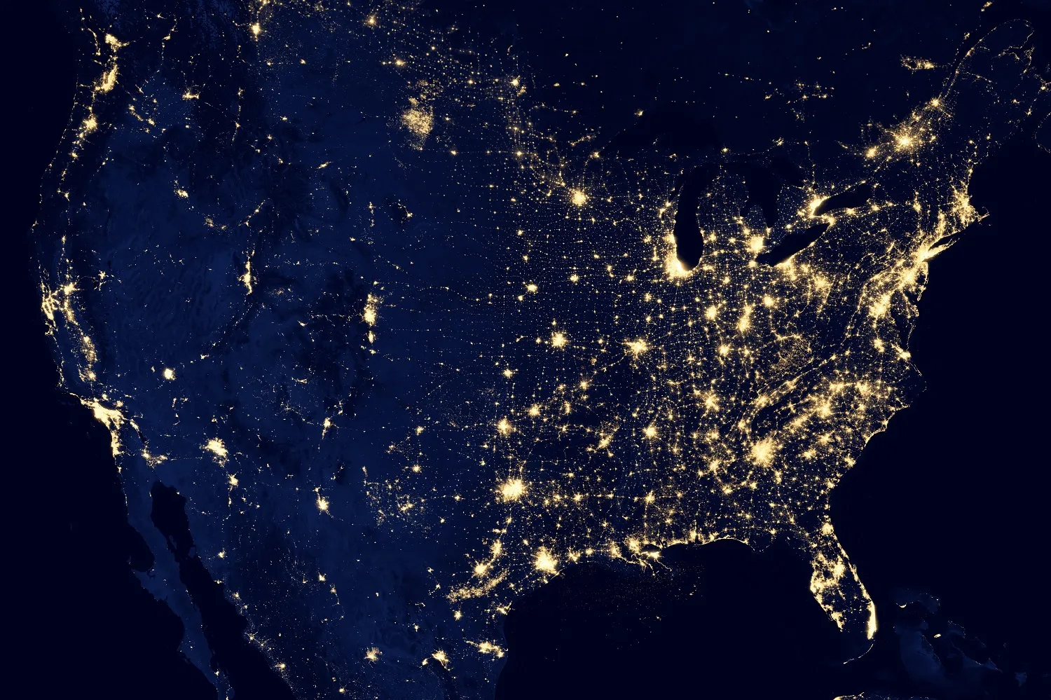 Satellite view of the United States at night showing city lights across the nation